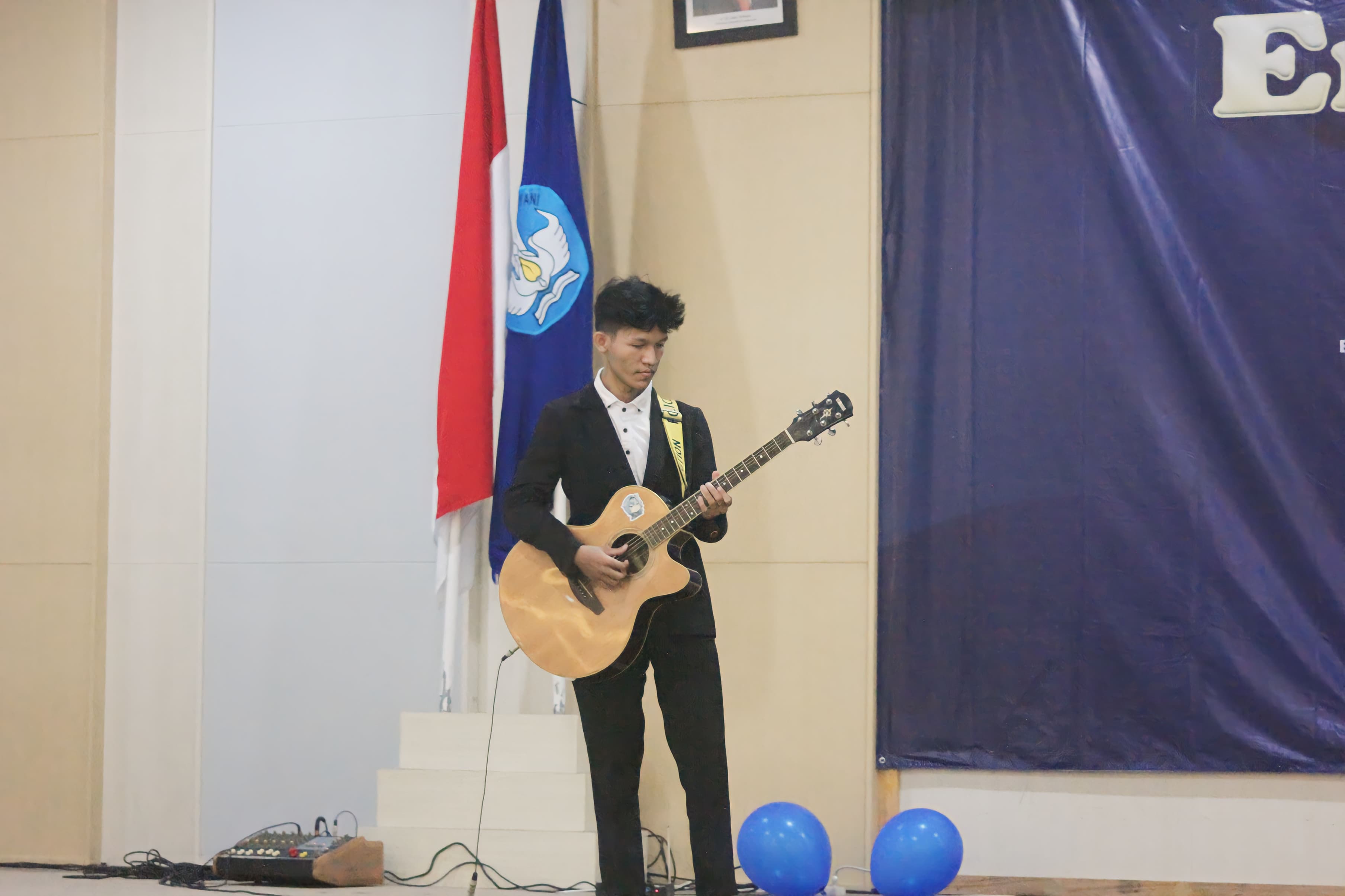 Friesko playing guitar at a school event